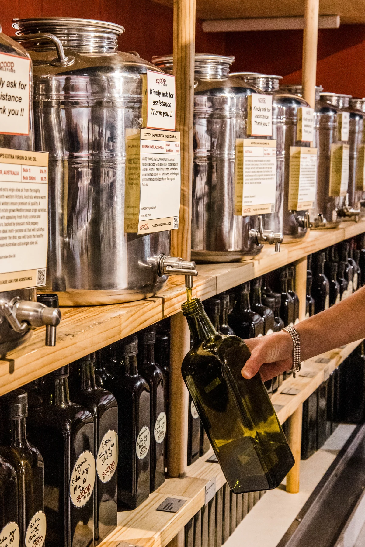 Olive oil being refilled from a Scoop Wholefoods dispenser